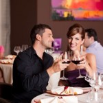 happy couple at restaurant table toasting
